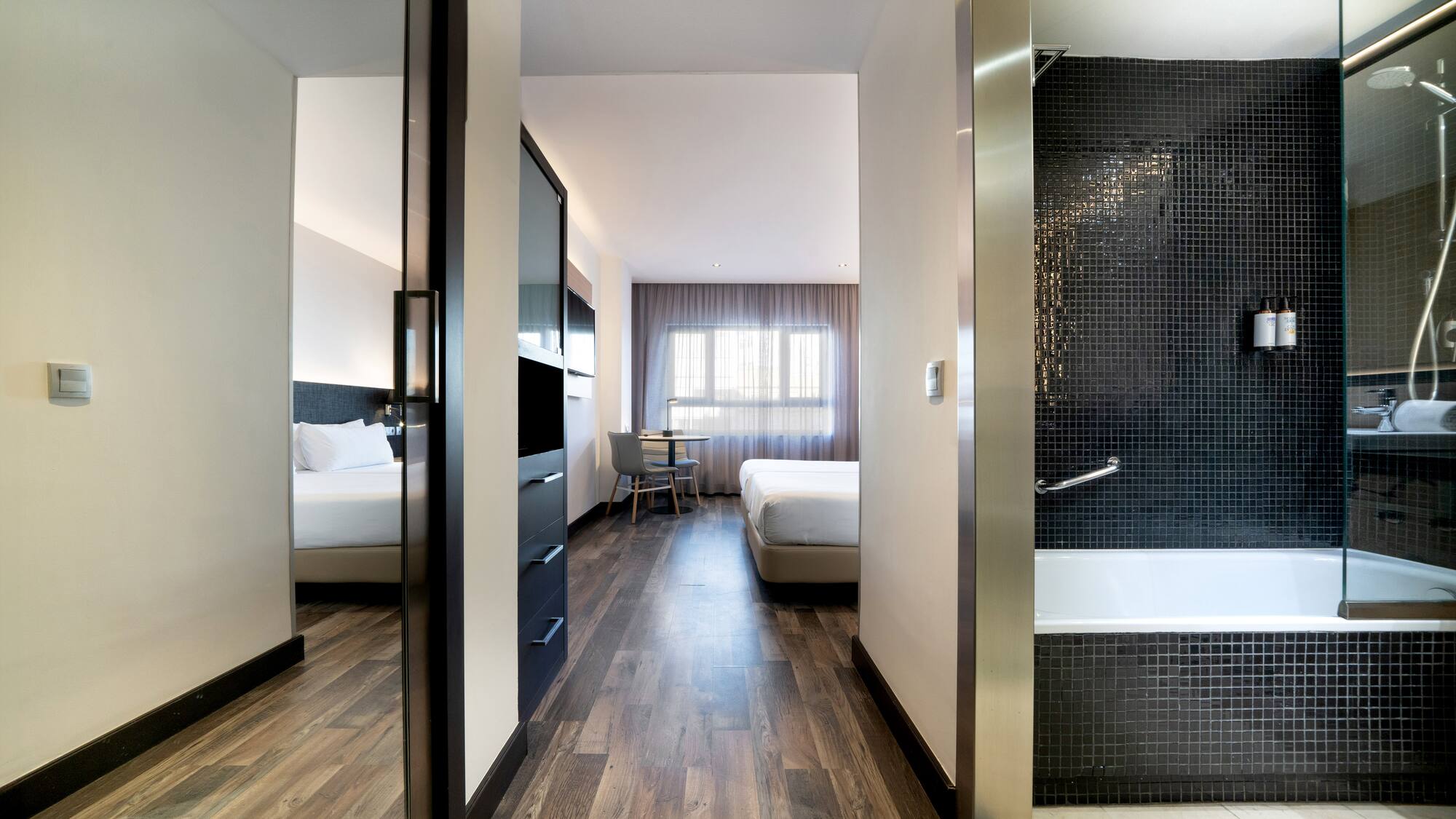 a room with a bathtub and beds