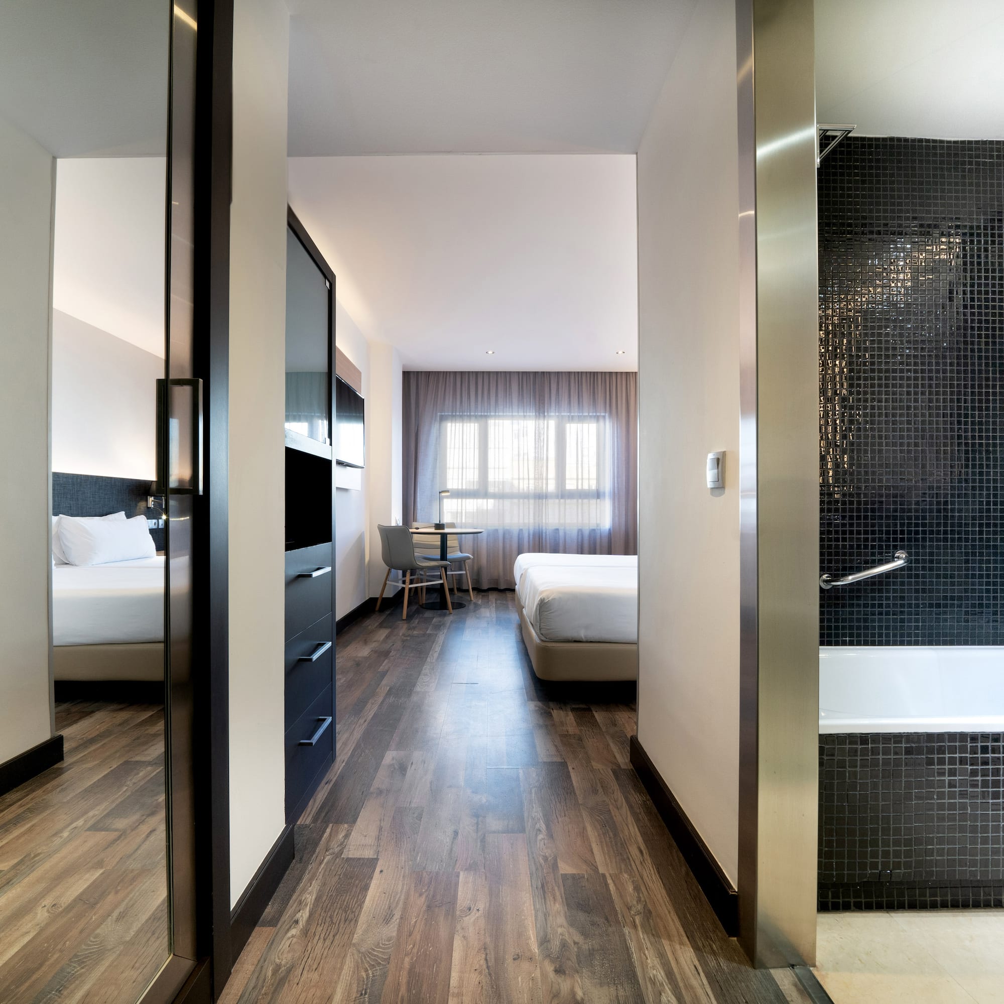 a room with a bathtub and beds