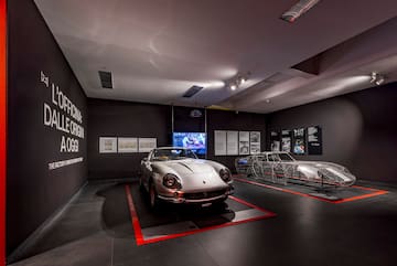 a car in a room with several metal sleds