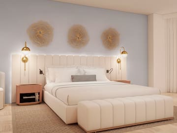 a bed with a white headboard and gold lights