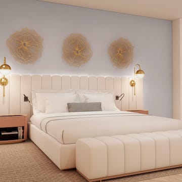 a bed with a white headboard and gold lights